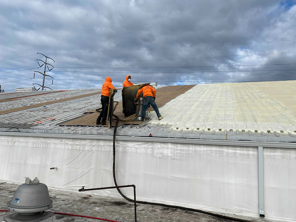 The image is of our team actively working to restore a commercial roof.