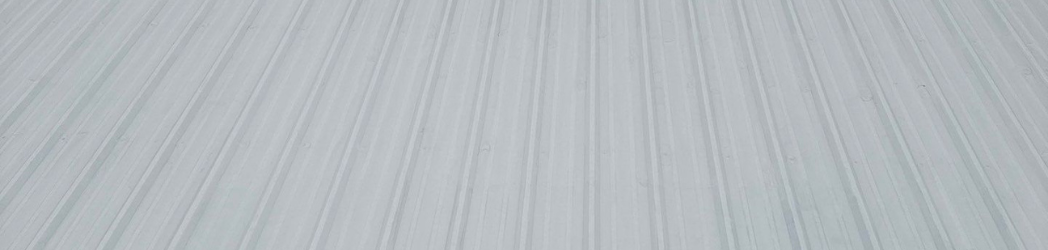 The image is of a metal roof restored with a silicone solution.