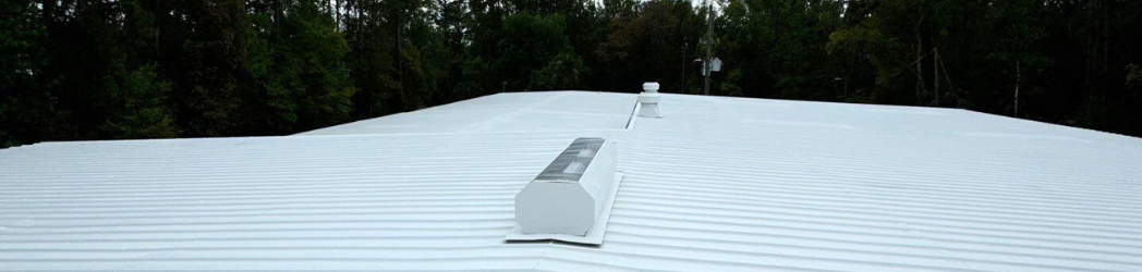 The image is of a metal roof restored with an acrylic fluid-applied system.