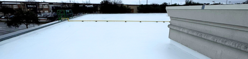 The image is of a retail roof restored with a White Hat Industrial fluid-applied solution.