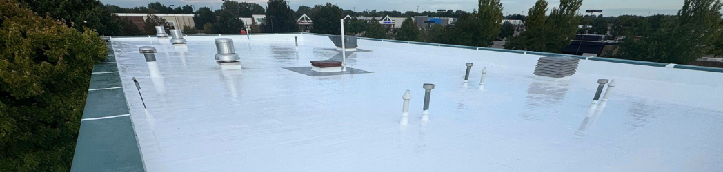 The image is of a roof restored with a fluid-applied roofing system by White Hat Industrial.