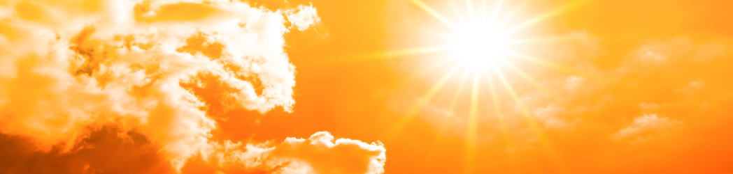 The sign is beaming bright among some clouds. The image is tinted orange.